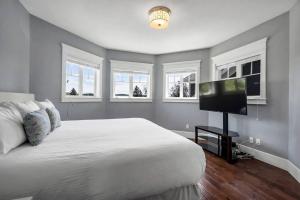 a bedroom with a bed and a flat screen tv at Comfort and joy in Prince George