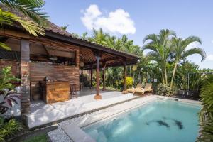 a villa with a swimming pool and a house at Candy Villa by Pramana Villas in Ubud