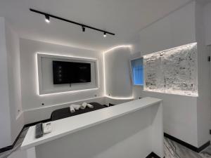 biały pokój z telewizorem na ścianie w obiekcie BS4 suite Luxury Madrid centro w Madrycie