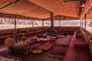 a large room with couches and tables in a building at Wadi Rum Fire Camp in Wadi Rum