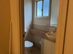 łazienka z toaletą, umywalką i oknem w obiekcie Esperance Pink Lake Tourist Park w mieście Esperance