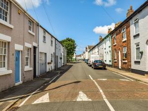 an empty street with buildings and a car parked on the road at Waterloo Sunset in Bootle