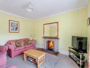 a living room with a couch and a fireplace at Meall Darroch in Inverey