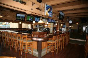 a bar in a restaurant with chairs and televisions at Lake Lawn Resort in Delavan