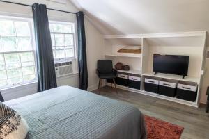 a bedroom with a bed and a flat screen tv at J Birds' Cottage Midtown Memphis in Memphis