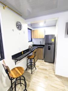 uma cozinha com um frigorífico, uma mesa e cadeiras em Apartaestudio para estrenar La Quinta em Ibagué