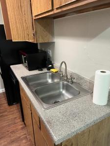 uma cozinha com um lavatório de aço inoxidável numa cozinha em Lovely 1-Bedroom Townhome with Nice Amenities em Houston