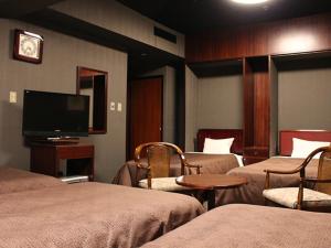 a hotel room with two beds and a flat screen tv at HOTEL LiVEMAX BUDGET Yokohama Tsurumi in Yokohama