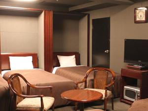 横浜市にあるホテルリブマックスBUDGET横浜鶴見のベッド2台とテレビが備わるホテルルームです。