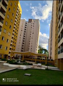 dos edificios altos con un parque delante de ellos en Apartamento moderno com 03 quartos e 02 garagens, en Campinas