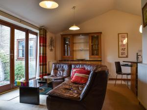 a living room with a leather couch and a table at Harvest View in Coton