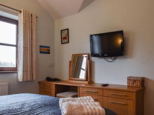 a bedroom with a mirror and a tv on the wall at Harvest View in Coton