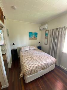 a bedroom with a bed with a striped comforter at Sailors Rest in Brisbane