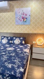 Schlafzimmer mit einem blauen und weißen Bett und einem Schreibtisch in der Unterkunft Homestay New Life- Hạ Long in Hạ Long