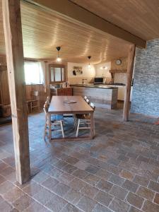 une grande chambre avec une table en bois et une cuisine dans l'établissement Al'fagne de boca, à Bertogne