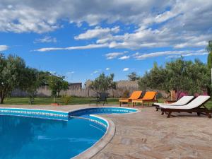 una piscina con sedie a sdraio accanto a un cortile di Cabaña del Sol con pileta exclusiva a San Rafael