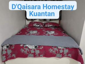 een bed in een kamer met een rode sprei bij D'Qaisara Homestay Kuantan in Kampong Bugis