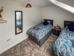 a bedroom with two beds and a mirror at No, 1 Fox Burrow-uk44306 in Lenwade