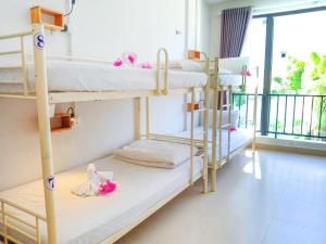 a room with bunk beds with a balcony at Bed Station Hostel & Pool Bar Hội An " Former Sunflower" in Hoi An