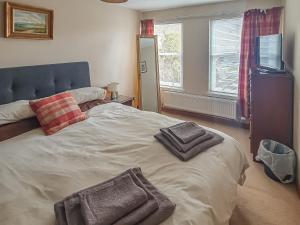 a bedroom with a bed with two towels on it at Harbour View House in Anstruther