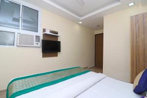 una camera con letto, TV e armadi di Collection O 10795 Hotel Nandgiri a Nuova Delhi