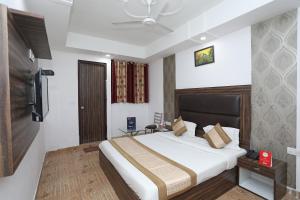 una camera con un grande letto e una televisione di Collection O 10795 Hotel Nandgiri a Nuova Delhi