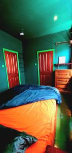 a bedroom with red and green doors and a bed at Copper Cottage tucked away near Brighton Station in Brighton & Hove