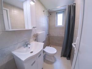 a white bathroom with a sink and a toilet at Milutinn-Trešnja in Soko Banja