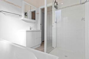阿勒达拉Fish Cottage Ulladulla - Linen not supplied - 3 bedroom house - sleeps 8 - pet friendly的带淋浴和水槽的白色浴室