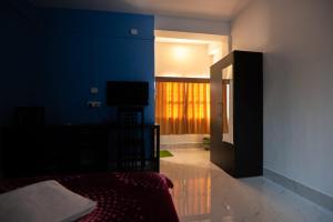 ein Schlafzimmer mit einem Bett und einem TV in einem Zimmer in der Unterkunft Jungle Eco Mansion in Kāziranga