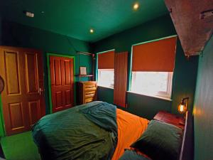 - une chambre avec des murs verts et orange et un lit dans l'établissement Copper Cottage tucked away near Brighton Station, à Brighton et Hove