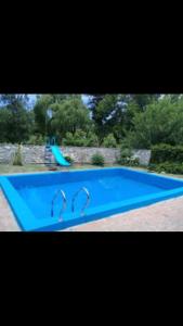 a blue swimming pool with two faucets on it at Cabaña Los Lirios in Huerta Grande