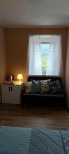 ein Schlafzimmer mit einem Sofa vor einem Fenster in der Unterkunft Mike's Rooms in Kobarid