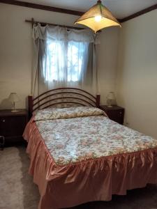 ein Schlafzimmer mit einem großen Bett und zwei Nachttischen in der Unterkunft Cabaña Los Lirios in Huerta Grande