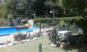 einen Pool mit 2 Stühlen und einem Tisch in der Unterkunft Cabaña Los Lirios in Huerta Grande