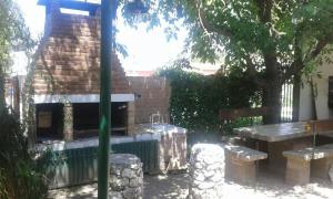 ein Backsteingebäude mit einem Picknicktisch und einer Bank in der Unterkunft Cabaña Los Lirios in Huerta Grande