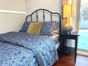 une chambre avec un lit et une lampe sur une table dans l'établissement Lily room near golf and banff costco newly renovated queen size bed Single bathroom sofa TV, à Calgary