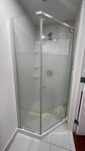a glass shower stall in a room with at Lily room near golf and banff costco newly renovated queen size bed Single bathroom sofa TV in Calgary