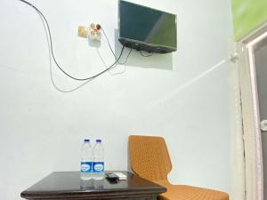 Un televizor și/sau centru de divertisment la Guest House Hj Muriyah Syariah Slawi Mitra RedDoorz