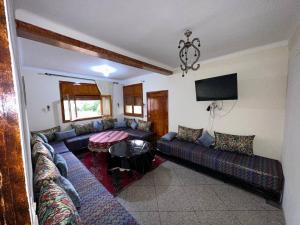 uma sala de estar com um sofá e uma mesa em La pivoine jaune em Ifrane