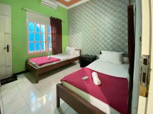 Un pat sau paturi într-o cameră la Guest House Hj Muriyah Syariah Slawi Mitra RedDoorz