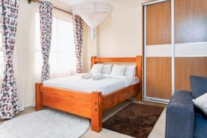 a bedroom with a wooden bed and a couch at City view luxury Suites in Nairobi