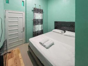 Antony Homestay near Pantai Pasir Putih Parbaba Mitra RedDoorz tesisinde bir odada yatak veya yataklar