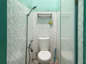 uma pequena casa de banho com WC e chuveiro em Antony Homestay near Pantai Pasir Putih Parbaba Mitra RedDoorz em Pangururan