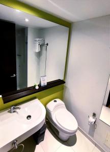 uma casa de banho com um WC, um lavatório e um espelho. em Scala 68 em Bogotá