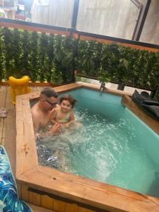 a man and a little girl in a jacuzzi tub at HOSTAL AONKEN in Coihaique
