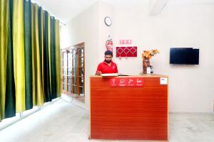 a man is sitting at a reception desk at OYO Flagship 18570 Hotel Jazz in Lālewāl