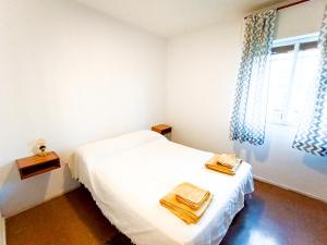 1 dormitorio con cama blanca y ventana en Depto Los Toneles en Mendoza