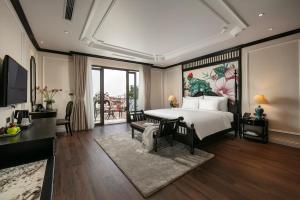 una camera da letto con un letto grande con un dipinto sul muro di Amira Hotel Hanoi a Hanoi