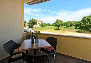 a table with chairs and a window with a view at Apartments Goltes in Lovrečica